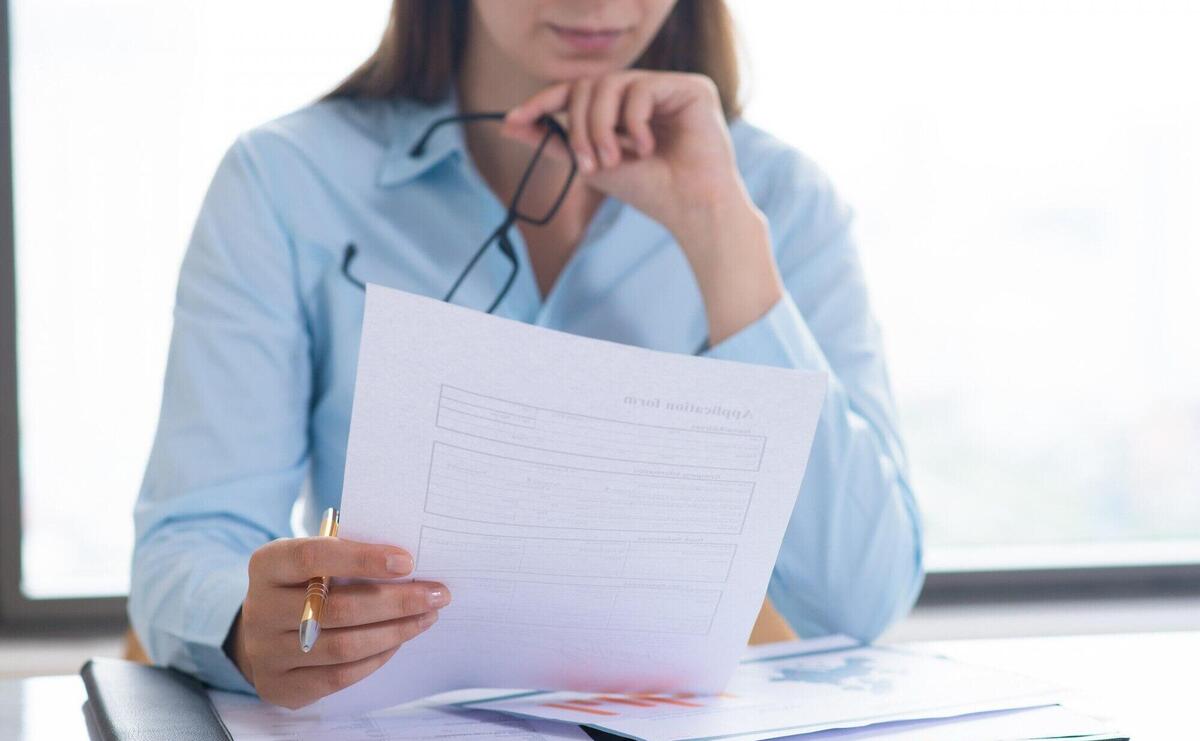 Closeup of woman holding and reading document