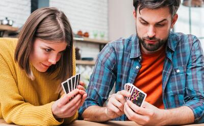 Young woman playing the cards at home