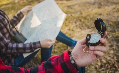 Close-up of hiker with a compass in his hand