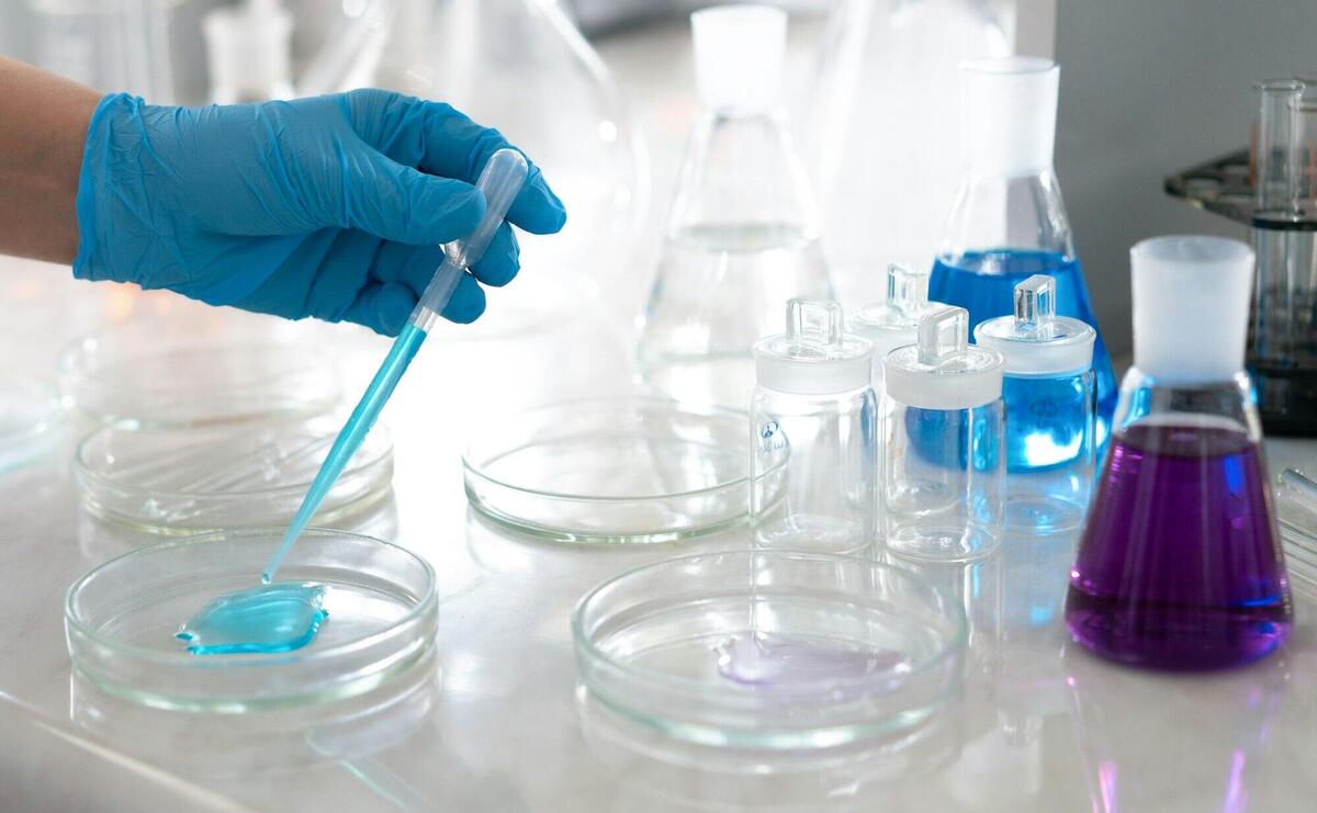 Chemist Hand in Glove over Table at Laboratory