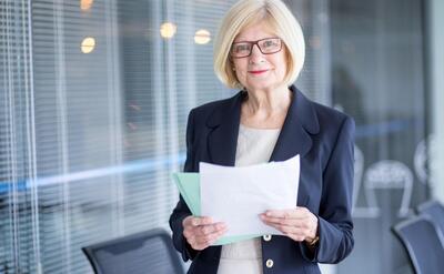 Portrait of positive female manager with documents