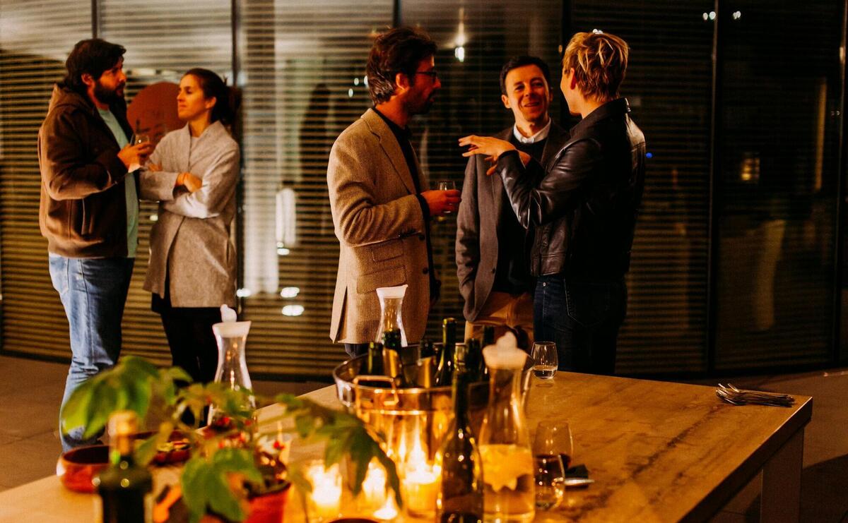 five person standing while talking each other