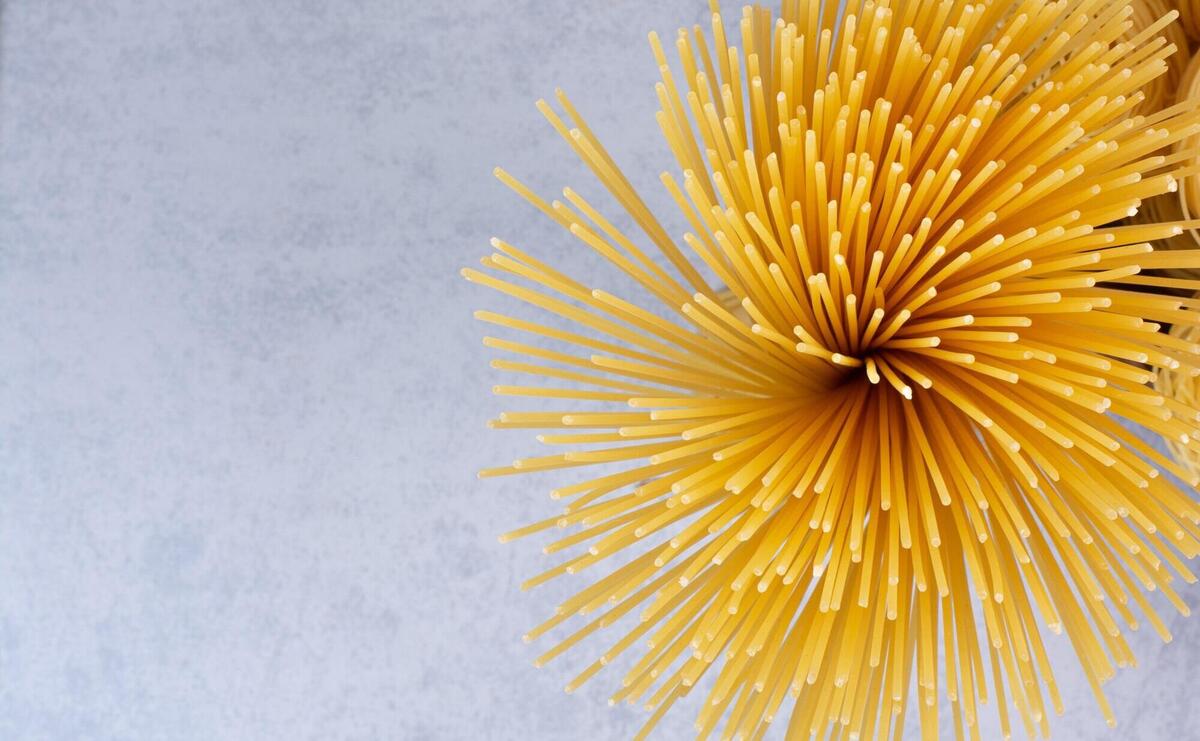 Delicious raw pasta on white surface