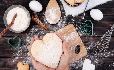 Hands holding heart-shaped dough