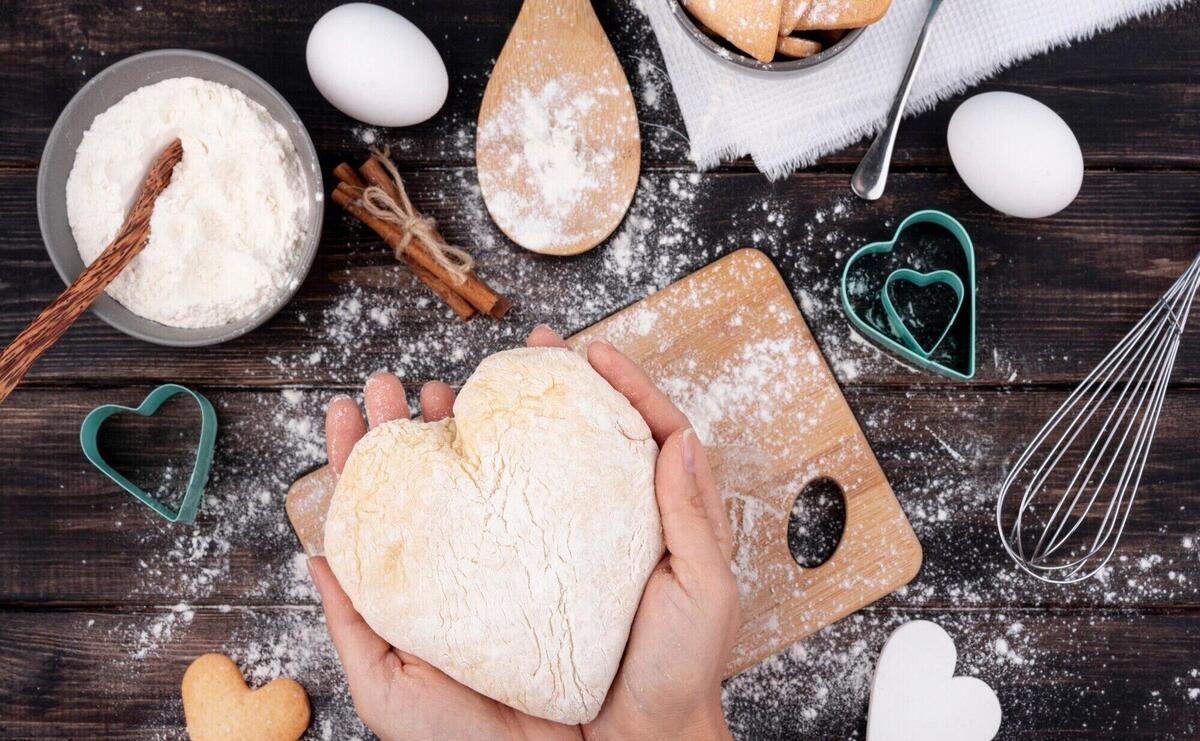 Hands holding heart-shaped dough