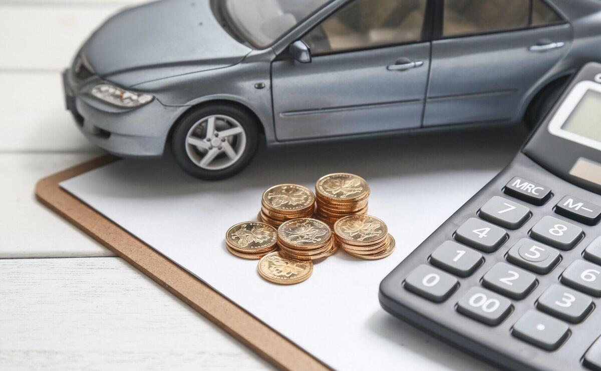 car model,calculator and coins on white table