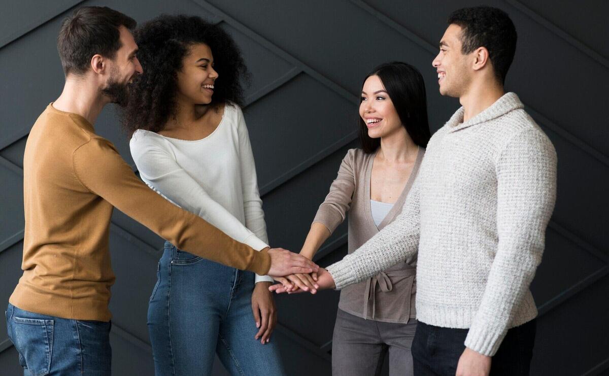 Group of young people holding hands together