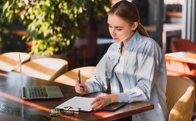 Beautiful woman writing on a clipboard