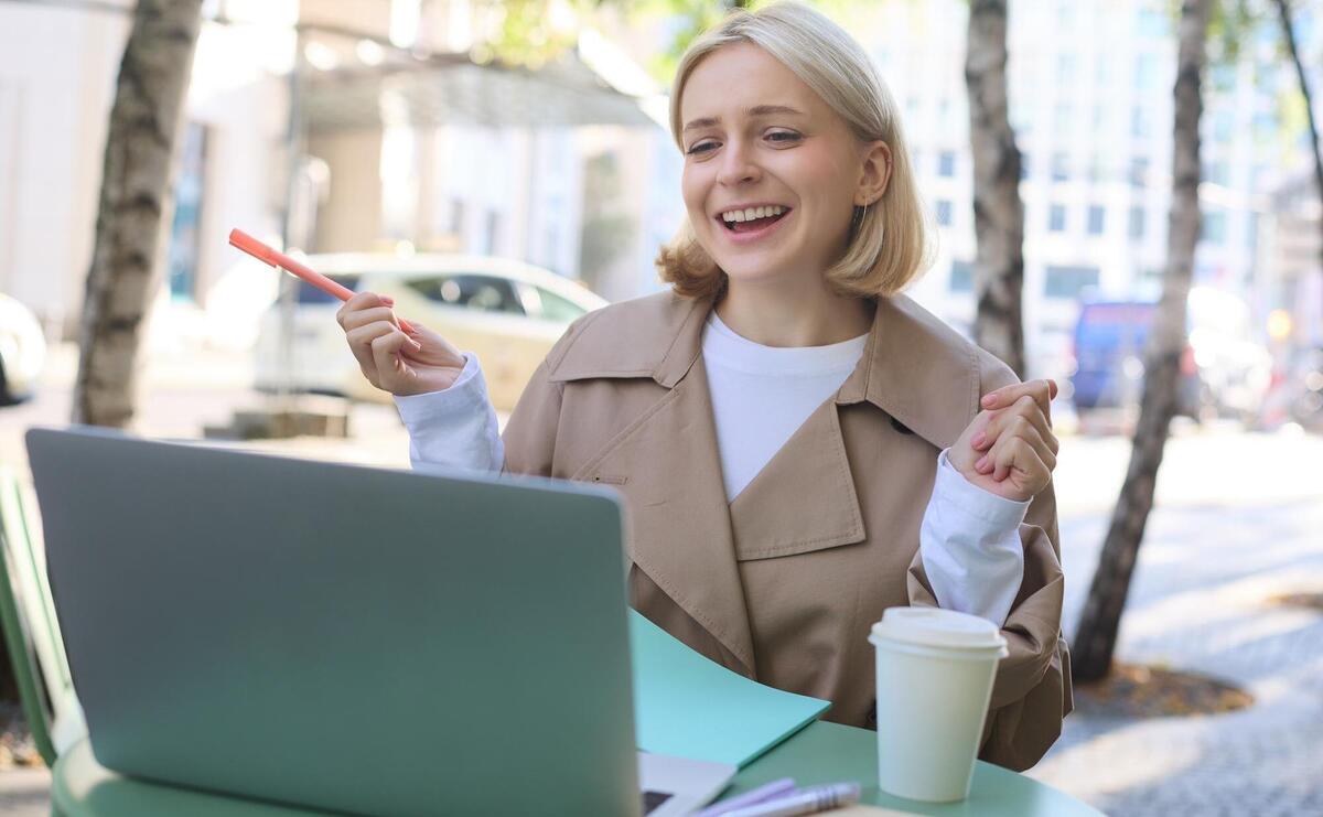 Portrait of young blond woman modern female model sitting in outdoor cafe drinking coffee connects