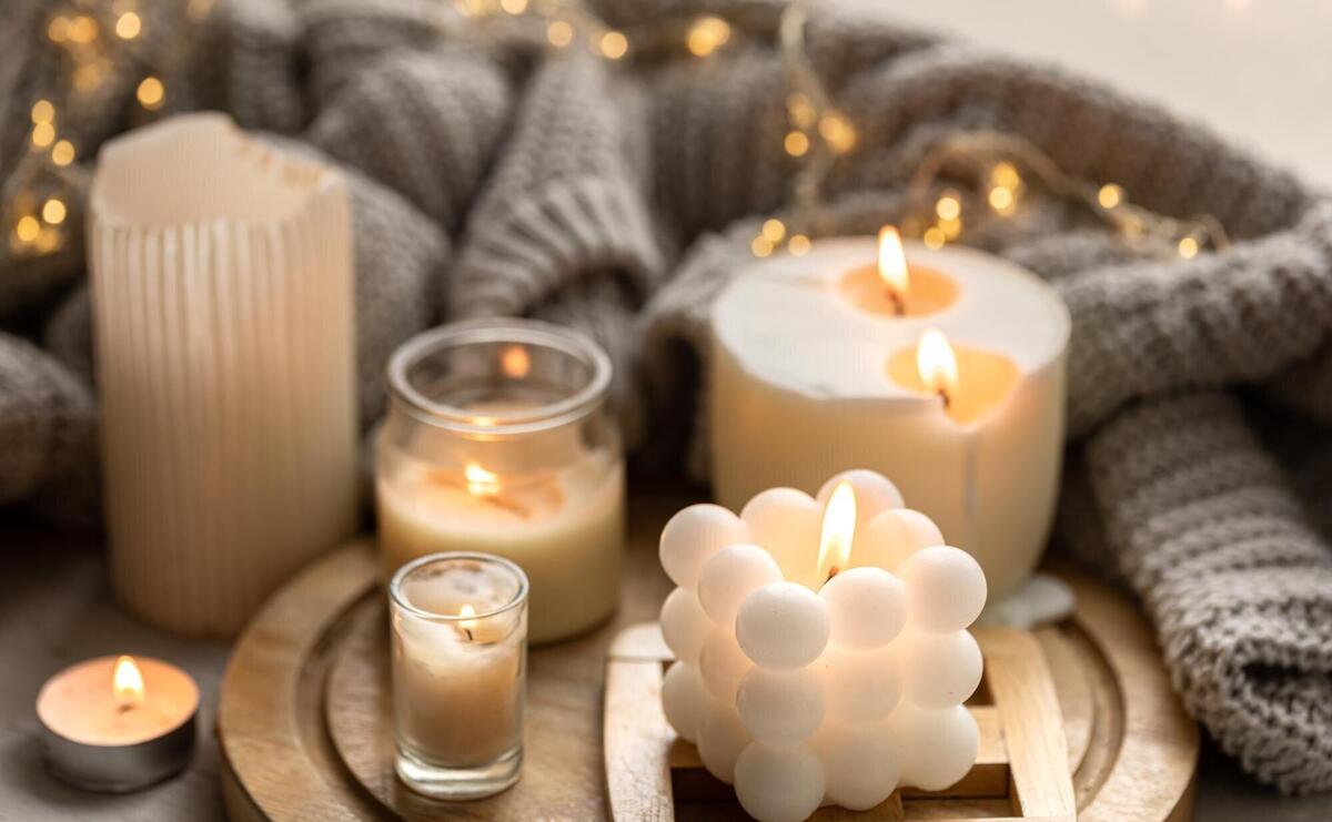 A cozy composition with candles a knitted element and a garland