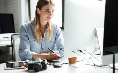 Cheerful young woman work in office using computer