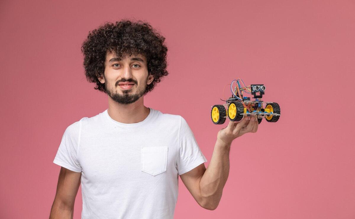 Front view young man holding his electronic robot