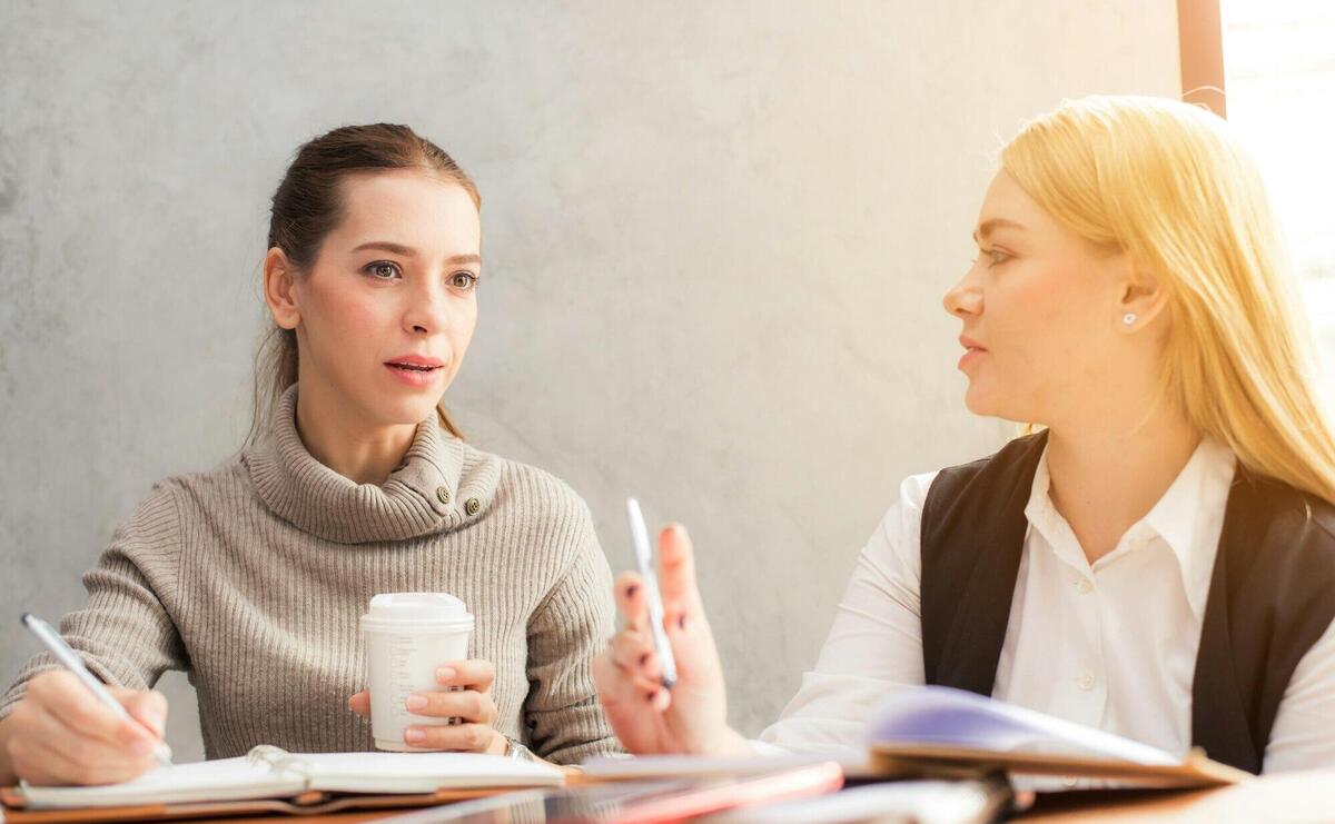 Two Women Holding Pen