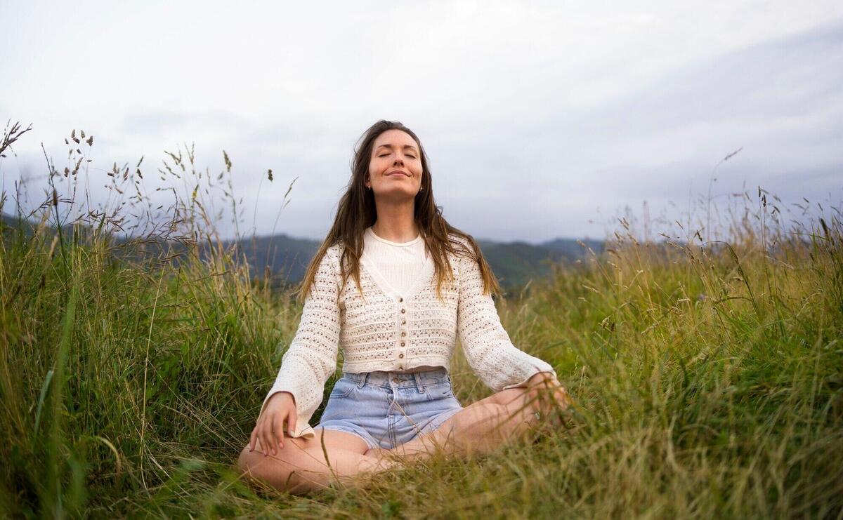 Front view smiley woman meditating outdoors