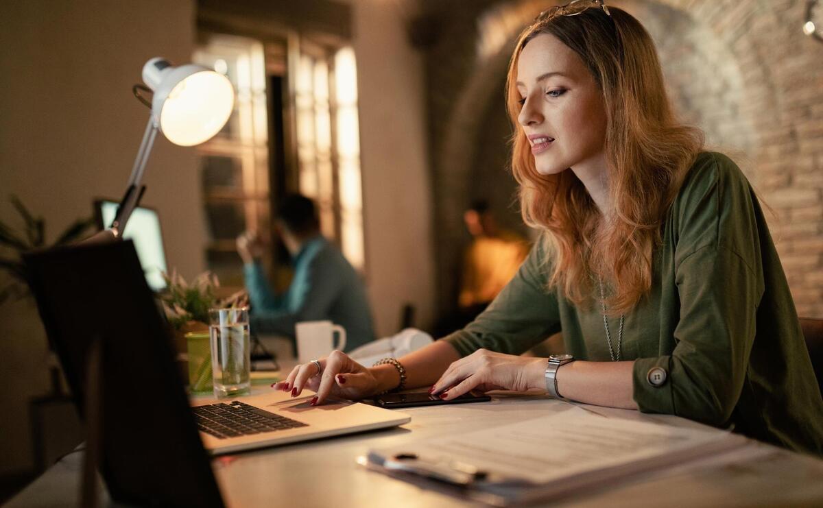 Young female entrepreneur using computer while working at night in the office