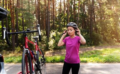 Medium shot woman putting on helmet