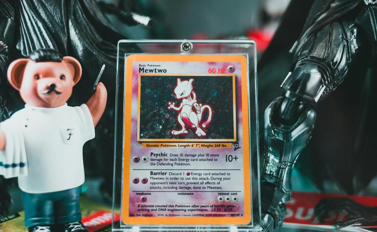 Close-up of rare Mewtwo Pokemon card displayed with various toy figures. Perfect for collectors.