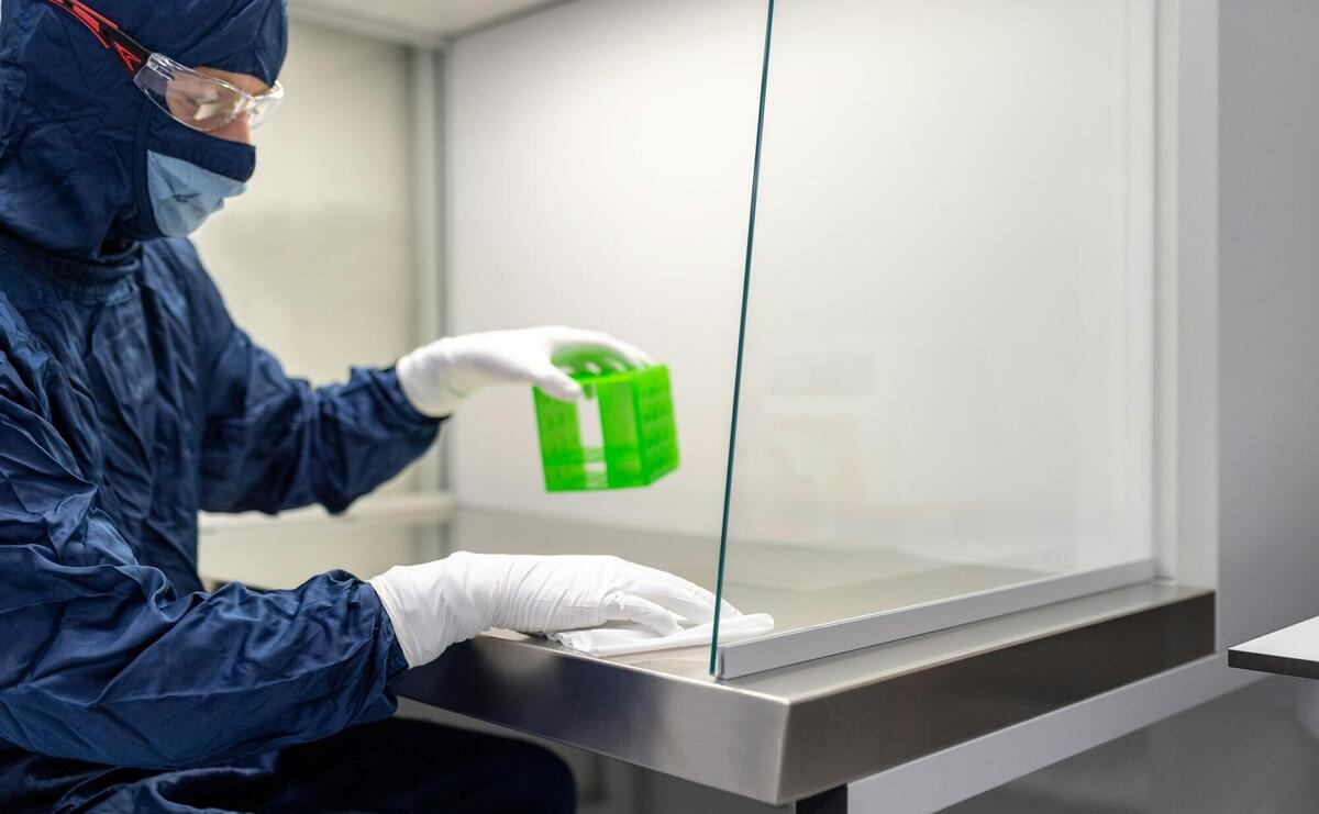 a person in a lab coat holding a green container