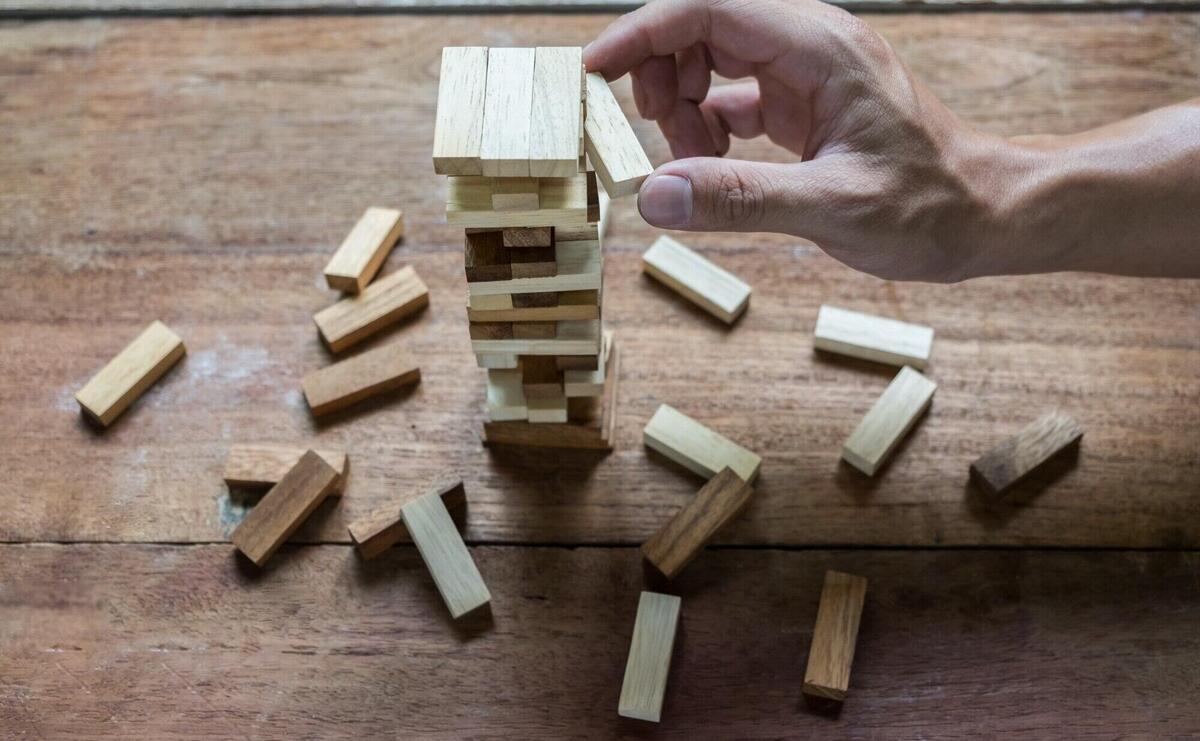 Planning, risk and strategy in business, businessman and engineer gambling placing wooden block on a tower.