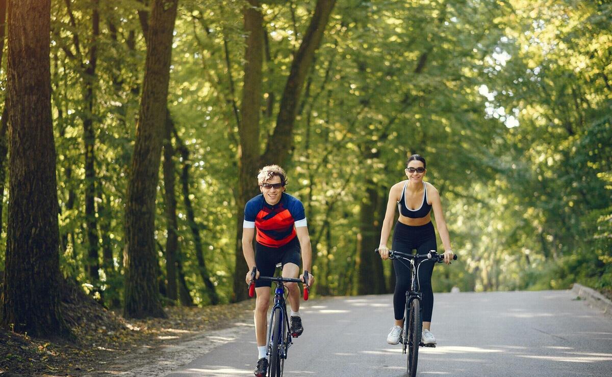 Sports couple riding bikes in summer forest