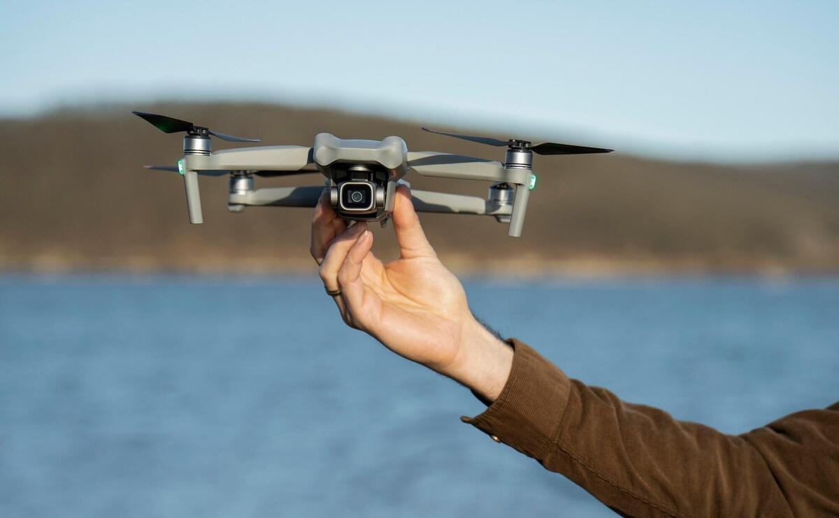 Man's hand holding drone outdoors