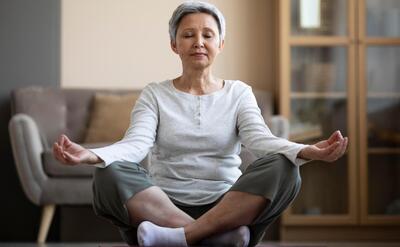 Mature woman meditating at home