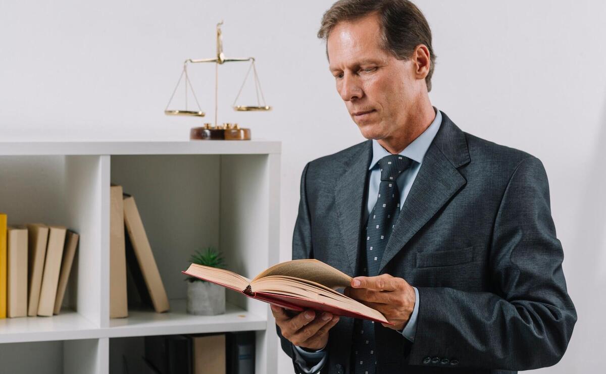 Mature male reading legal book in the courtroom