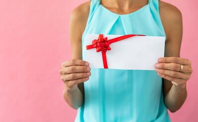 Woman holding an envelope with ribbon