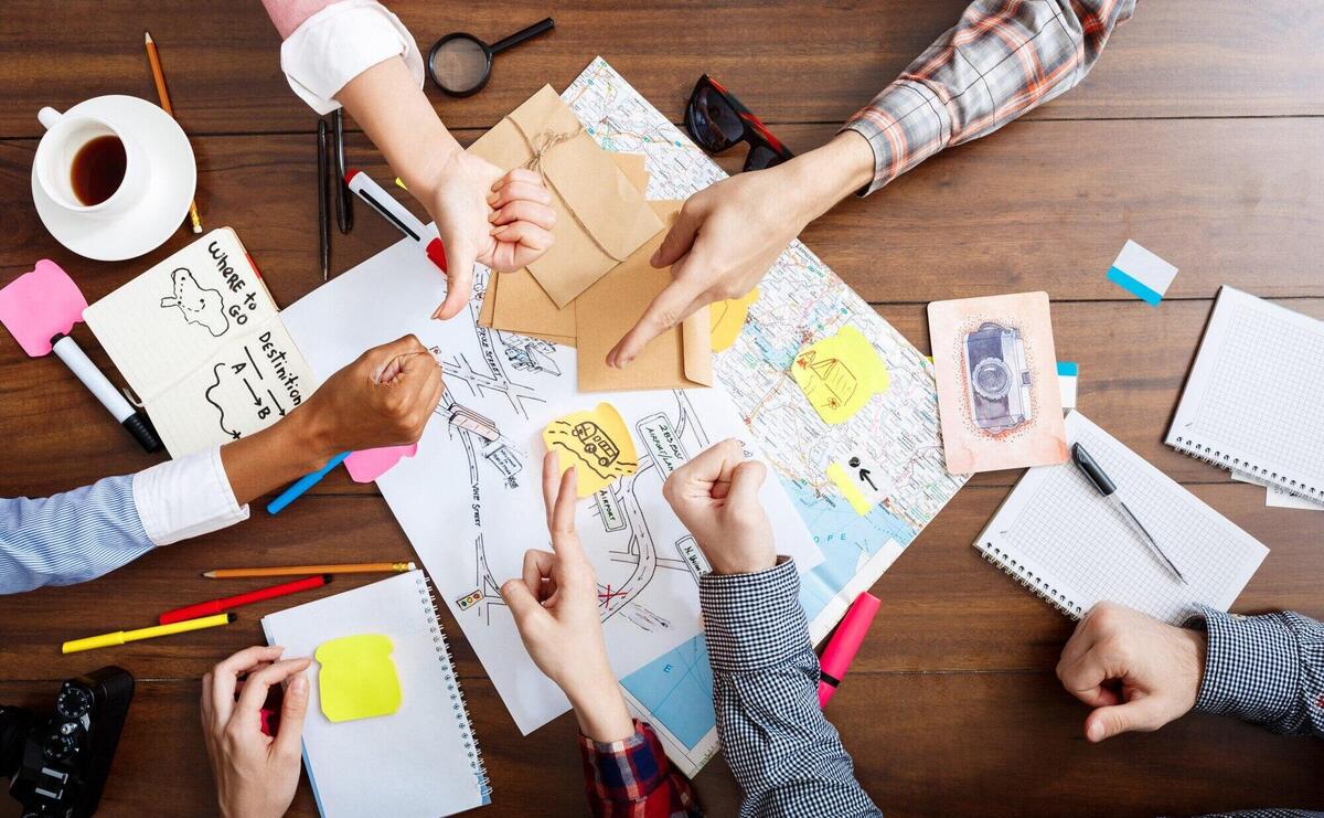  businessmen hands on wooden table with documents and drafts