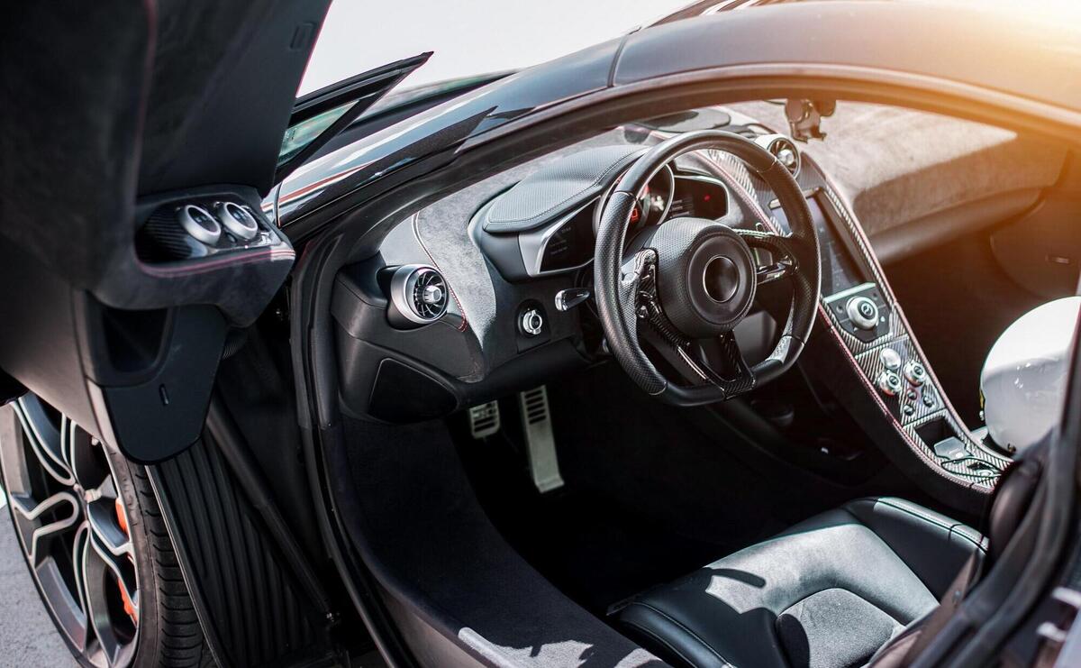 Black sport car front side salon view, black wheel with metallic silver color, direction, door open. 