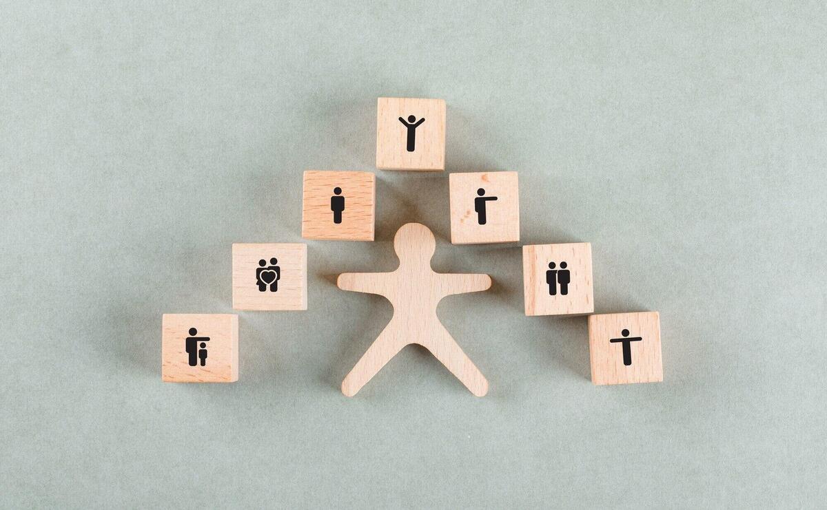 Success employee concept with wooden human, blocks with icons.