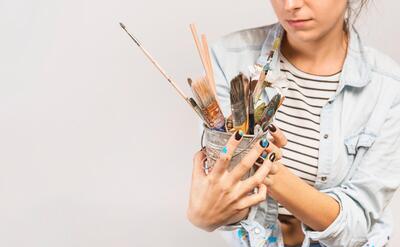 Portrait of female artist with paintbrushes