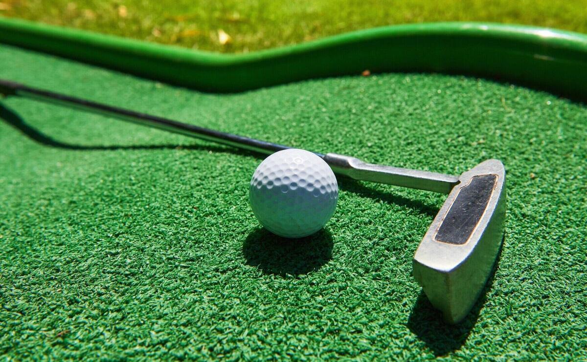 Golf ball and Golf Club on Artificial Grass.