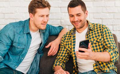 Portrait of a man showing something to his friend on smartphone