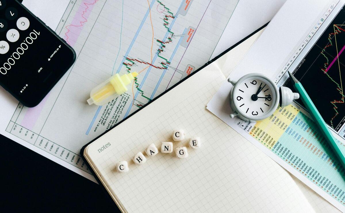 Top view of financial documents with charts, calculator, clock, and the word 'Change' in focus.