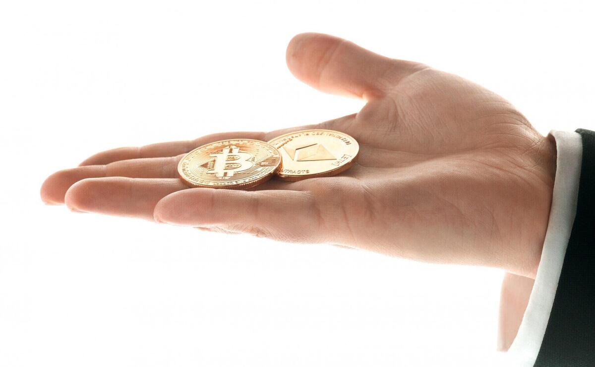 Male hand with golden bitcoin coins