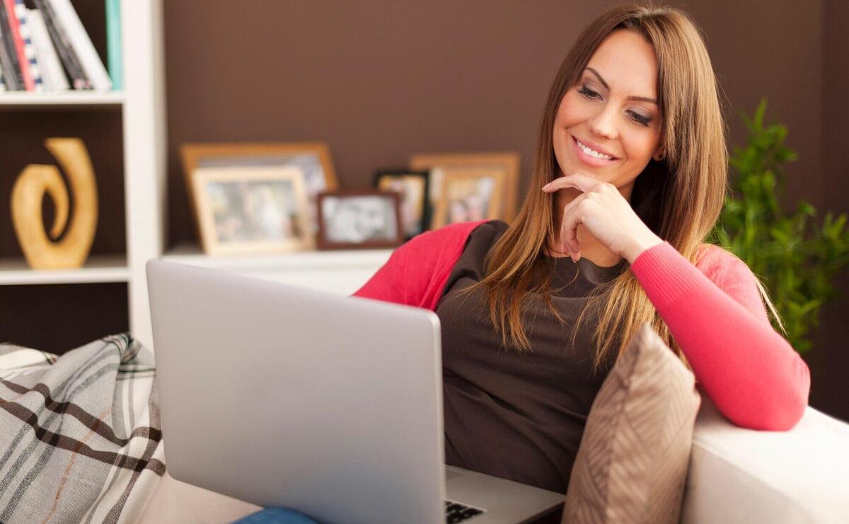 Smiling woman using laptop at home