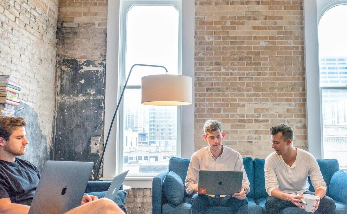 three men using MacBooks