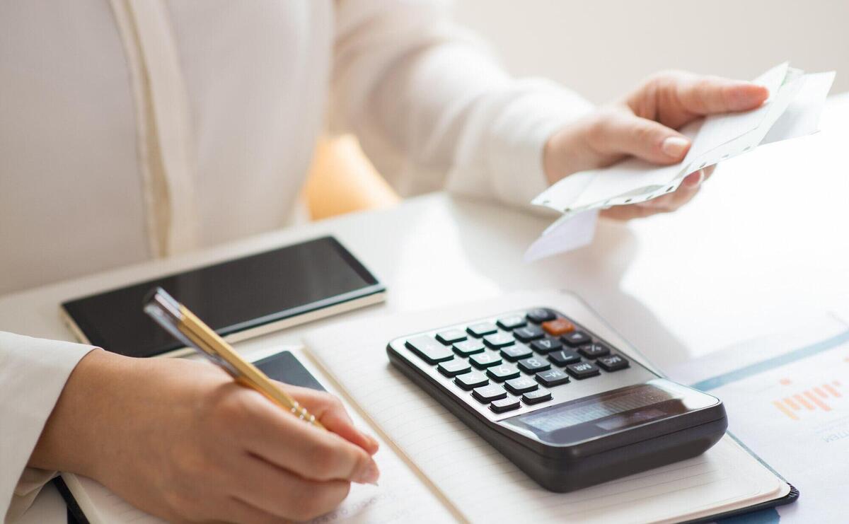 Closeup of person holding bills and calculating them