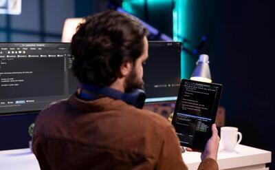 Man doing software quality assurance using tablet reading source code