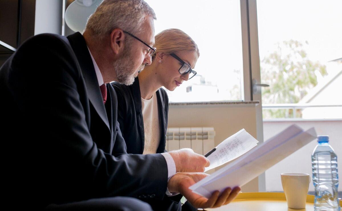 Portrait of business man and woman sitting in office discussing contract