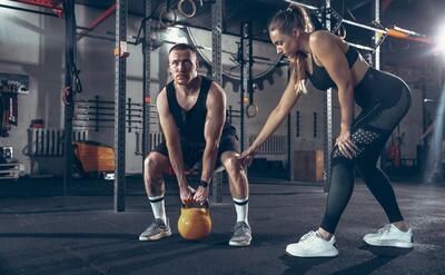 Athletic man and woman with dumbbells