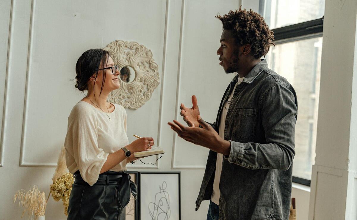 Man in Black Jacket Standing Beside Woman in White Shirt