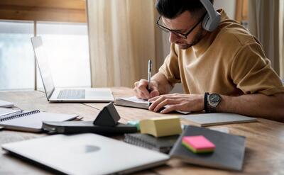 Young man writing on a notebook during study session