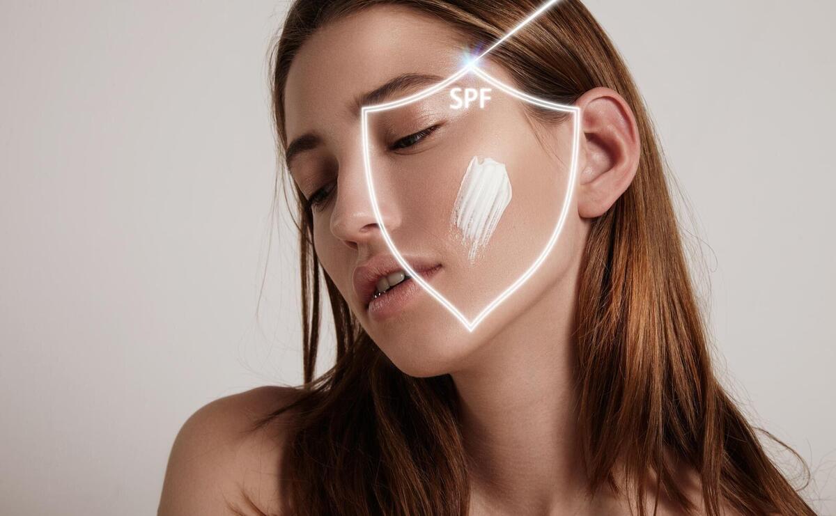 Woman's face into a shield makes spf protection from ray