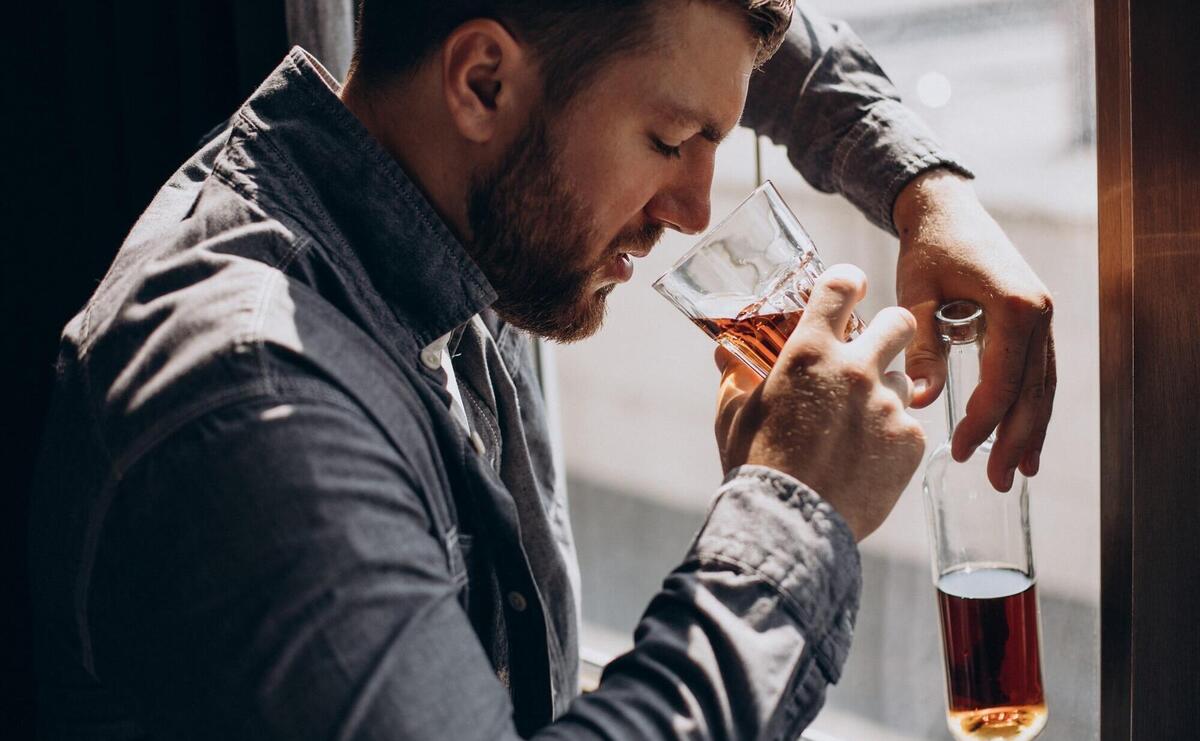 Man drinker depressed with bottle of whiskey