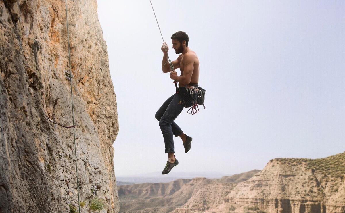 Strong man climbing on a mountain