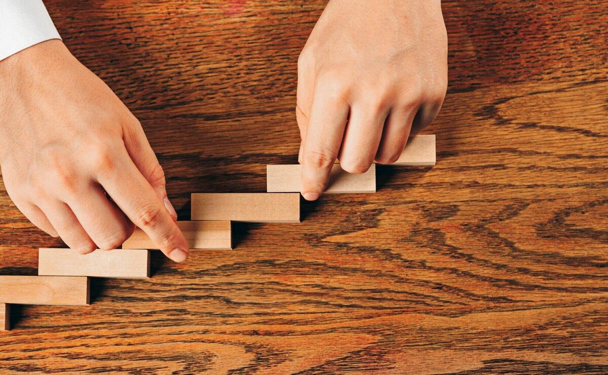 Man and wooden cubes on table. Management concept