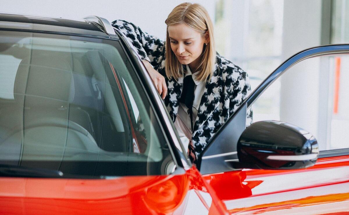 Young woman buying a car in a car showroom