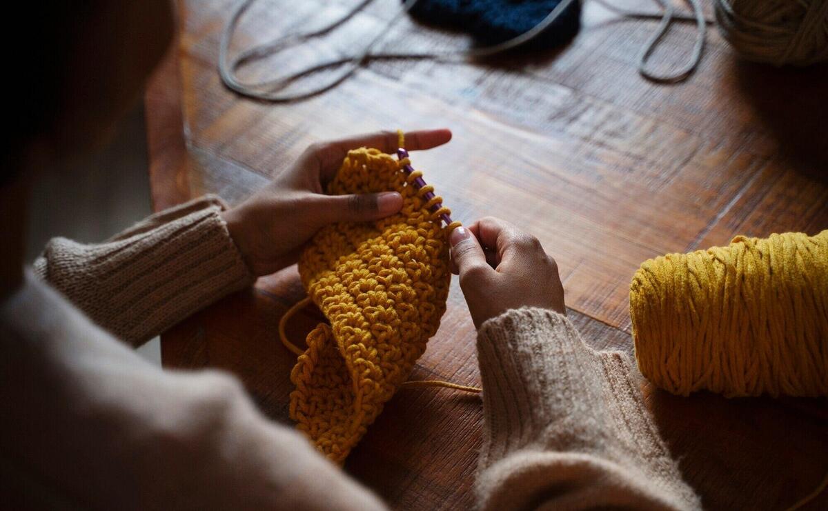 High angle young adult crocheting indoors